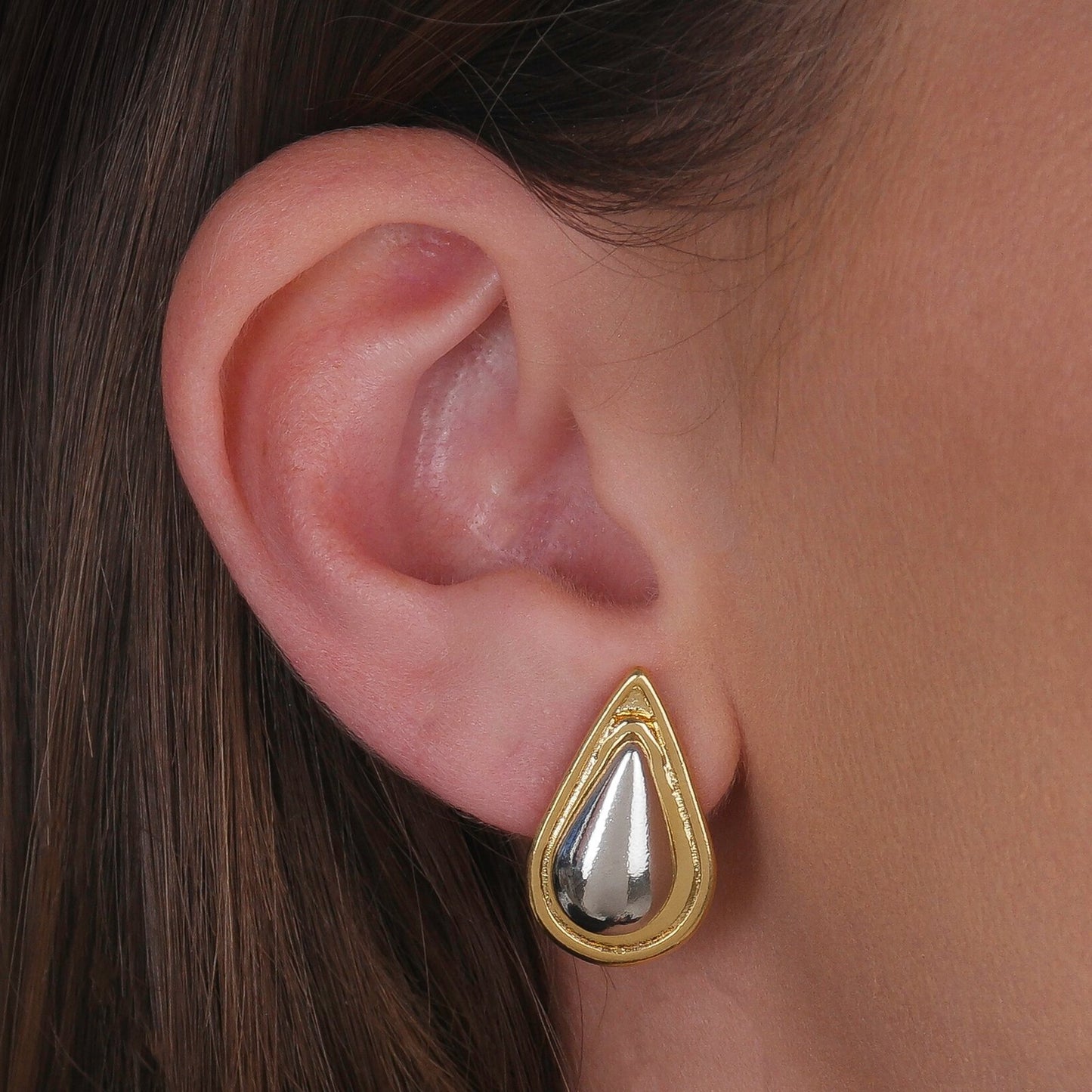 Modelo usando brinco formato gota dourado e prateado com banho de ouro 24k e ródio branco, semijoia elegante antialérgico