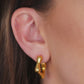 Modelo feminina com Brinco Dourado Orgânico Quadrado com Bordas Arredondadas 