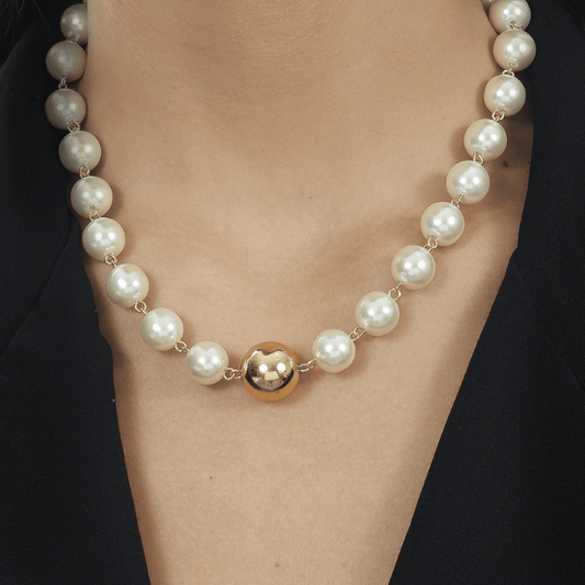Modelo com Colar Dourado de Pérolas e Bola
