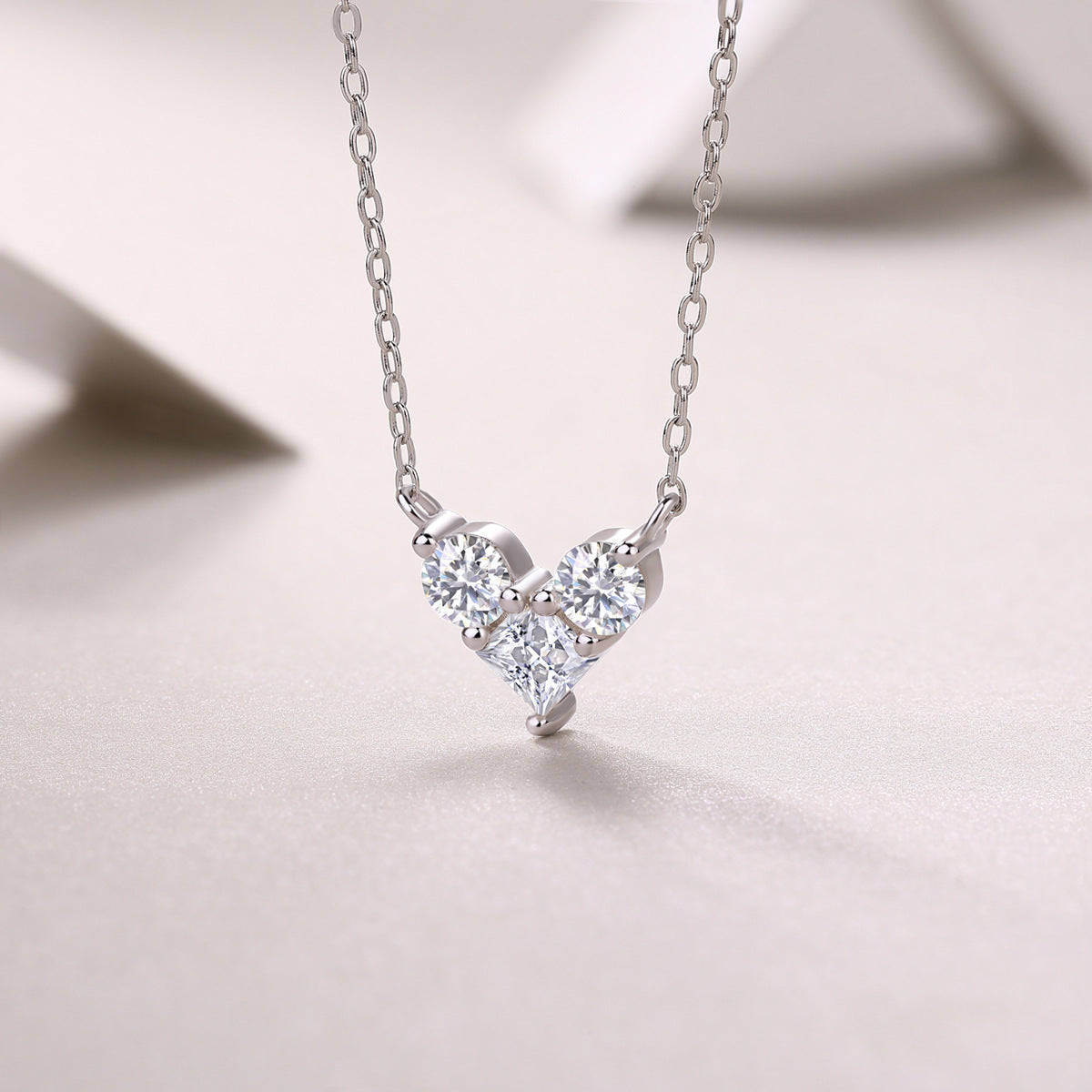 Colar Moissanite Coracao Triplo em Prata 925 fundo elegante
