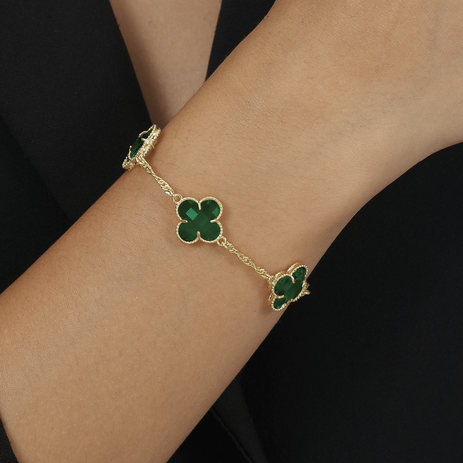 Modelo com Pulseira Dourada Trevos Zircônia Verde