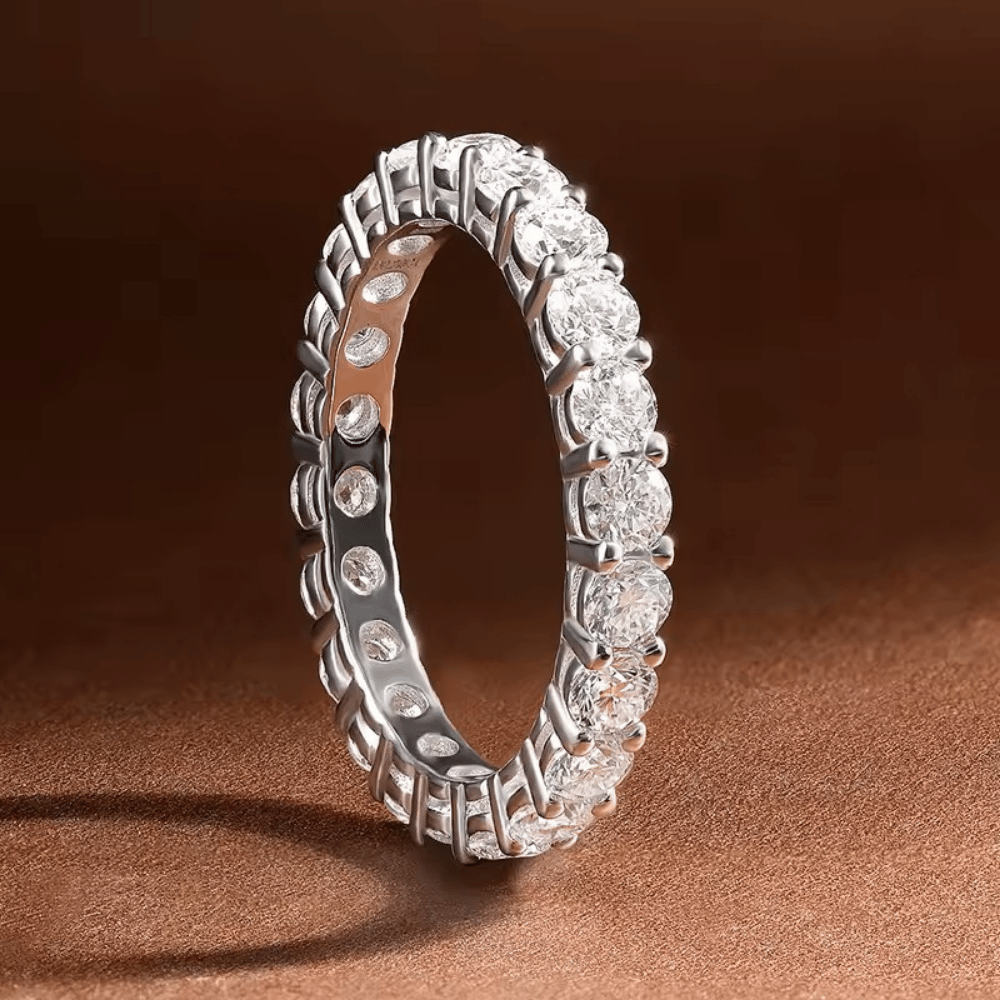 Anel inteiro cravejado com moissanite em prata 925 exposto em fundo elegante