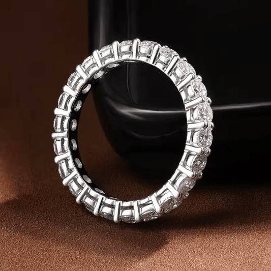 Anel inteiro cravejado com moissanite em prata 925 exposto em fundo elegante 1

