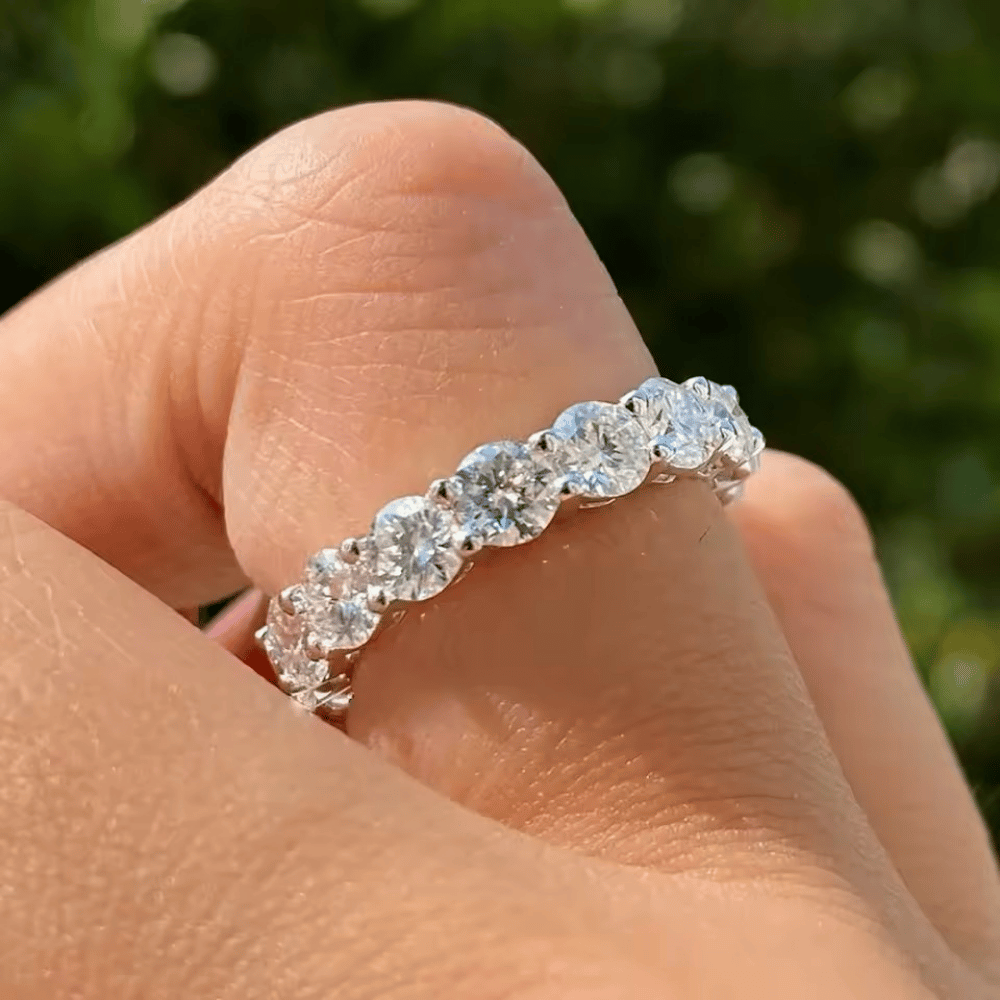 Close-up dedo com anel inteiro cravejado com moissanites em prata 925