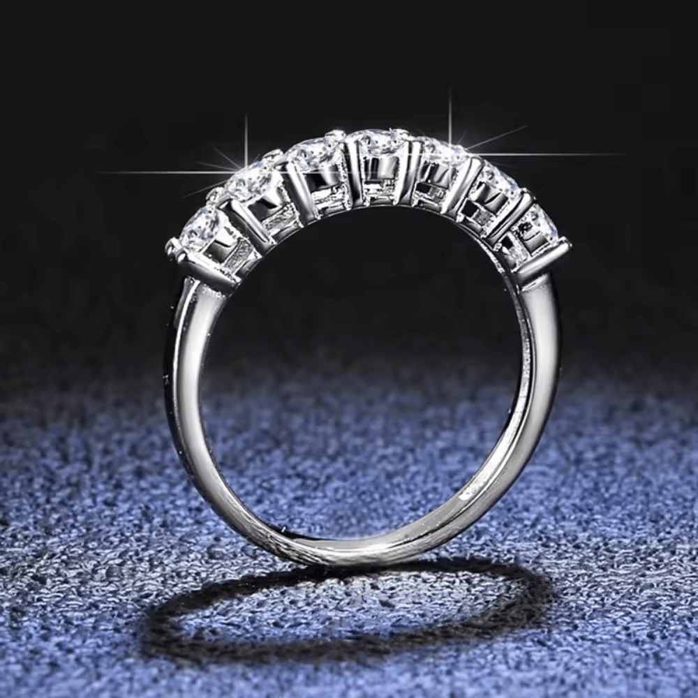 Anel meia aliança com 7 pedras de Moissanite em prata 925, vista frontal sobre fundo elegante
